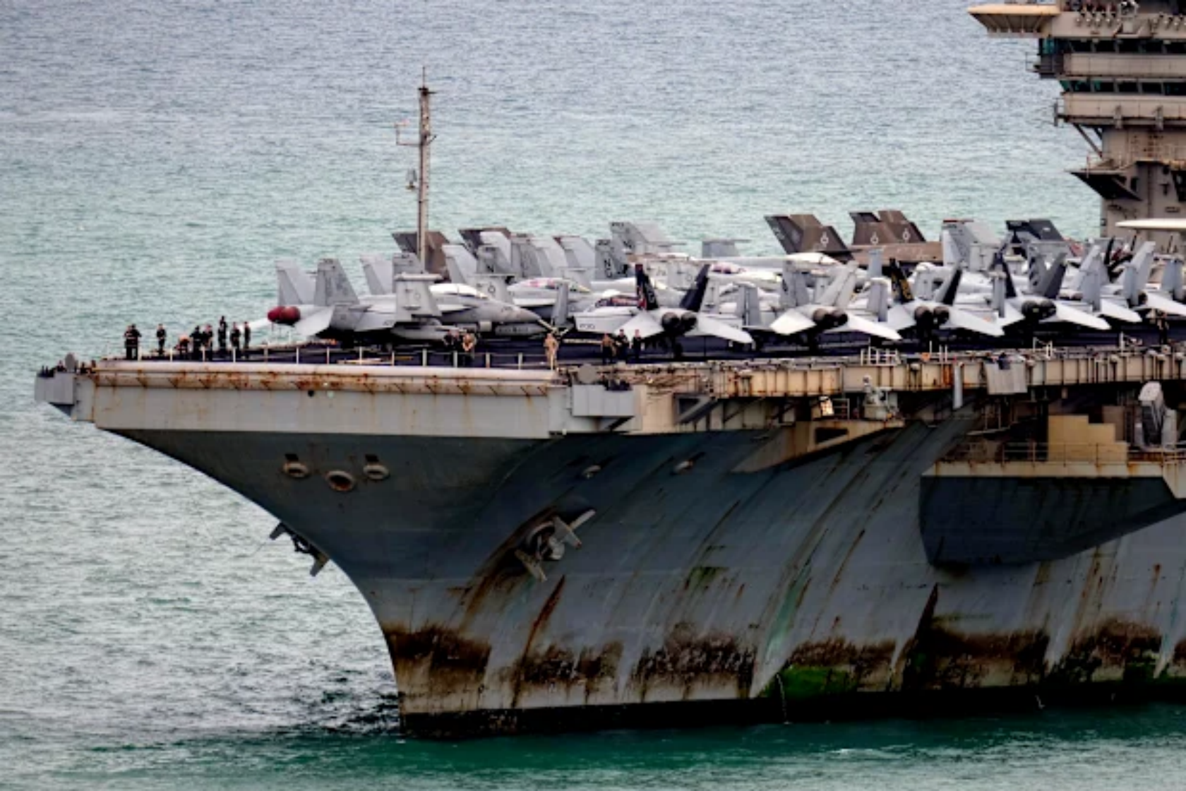 Bow of the USS Abraham Lincoln at sea, with aircraft parked on the flight deck.